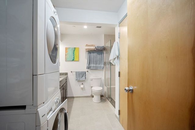 a bathroom with a granite countertop shower and a toilet