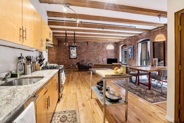 a view of a kitchen with kitchen island granite countertop a sink and a refrigerator