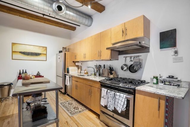 a kitchen with stainless steel appliances granite countertop a stove and a wooden cabinets