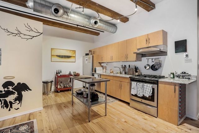 a kitchen with stainless steel appliances granite countertop a stove and cabinets