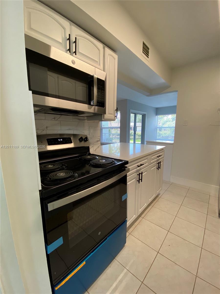 455 South Pine Island Road, Unit 110C Plantation, FL 33324 - Photo 6 of 30 a kitchen with stainless steel appliances a stove a microwave and a sink