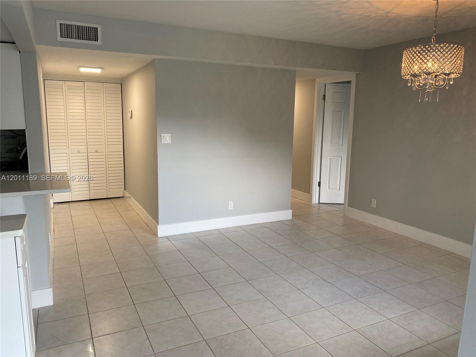 455 South Pine Island Road, Unit 110C Plantation, FL 33324 - Photo 9 of 30 an empty room with kitchen and chandelier fan
