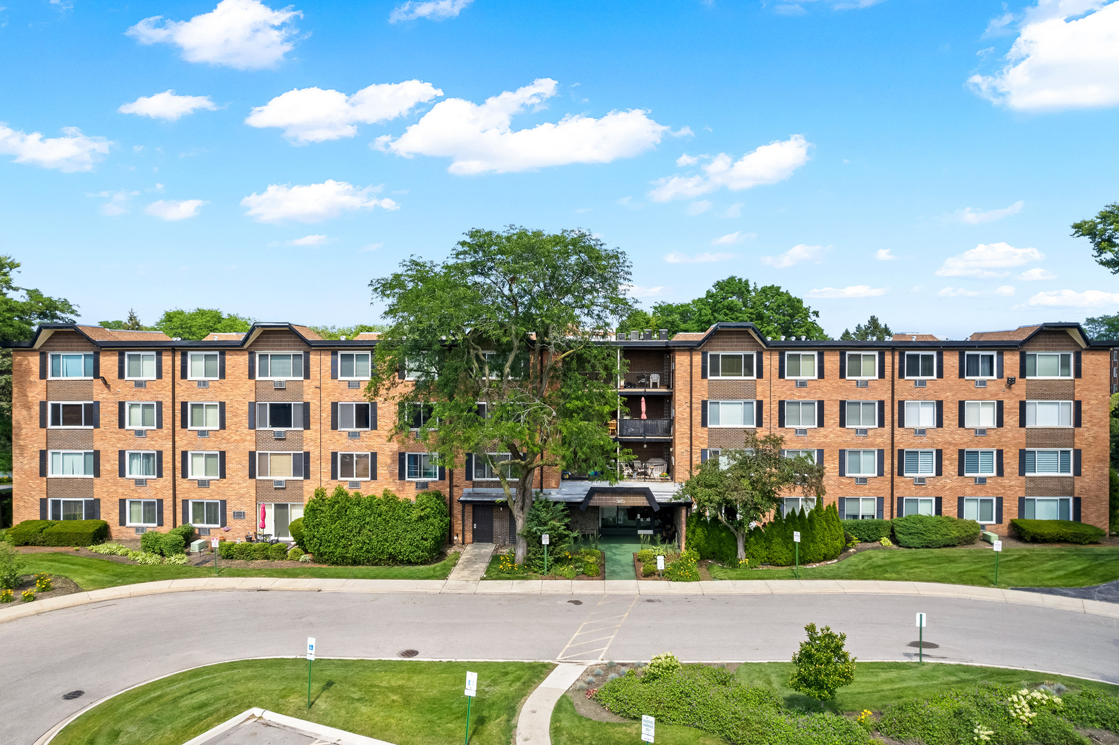 1207 South Old Wilke Road, Unit 209 Rolling Meadows, IL 60005 - Photo 1 of 22 a view of a brick building next to a yard