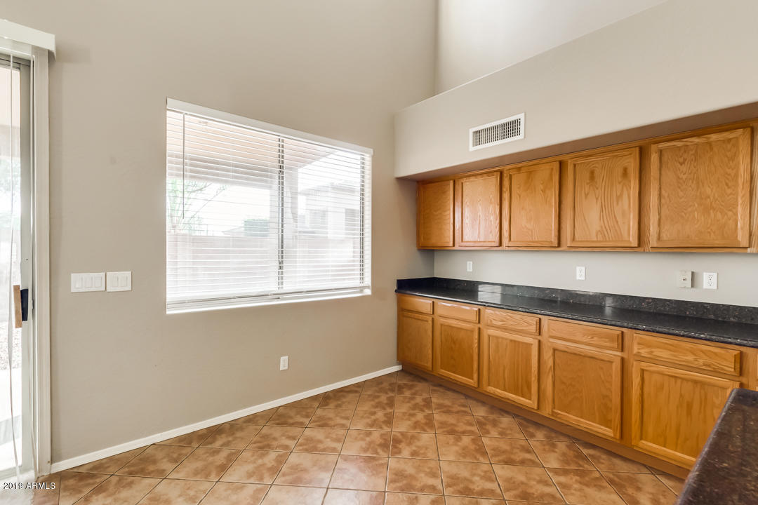 15917 West Calavar Road Surprise, AZ 85379 - Photo 12 of 40 a kitchen with granite countertop a sink cabinets and window