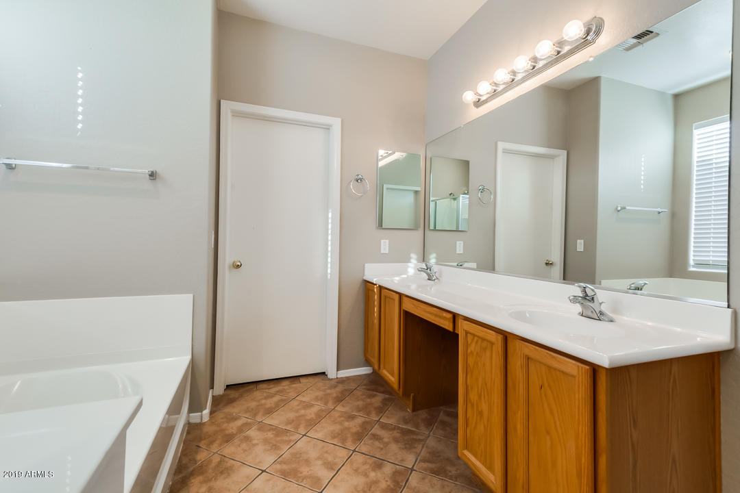 15917 West Calavar Road Surprise, AZ 85379 - Photo 18 of 40 a bathroom with a double vanity sink mirror and bathtub