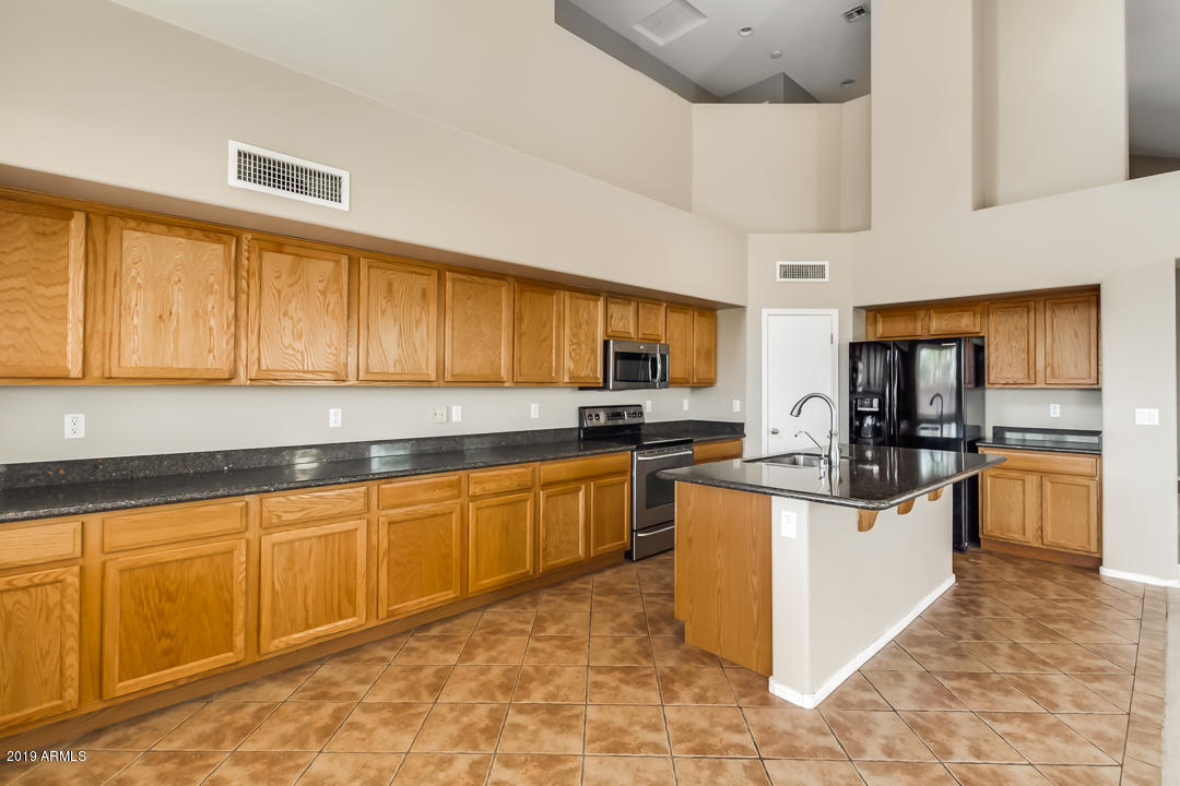 15917 West Calavar Road Surprise, AZ 85379 - Photo 2 of 40 a kitchen with stainless steel appliances granite countertop a stove sink and cabinets