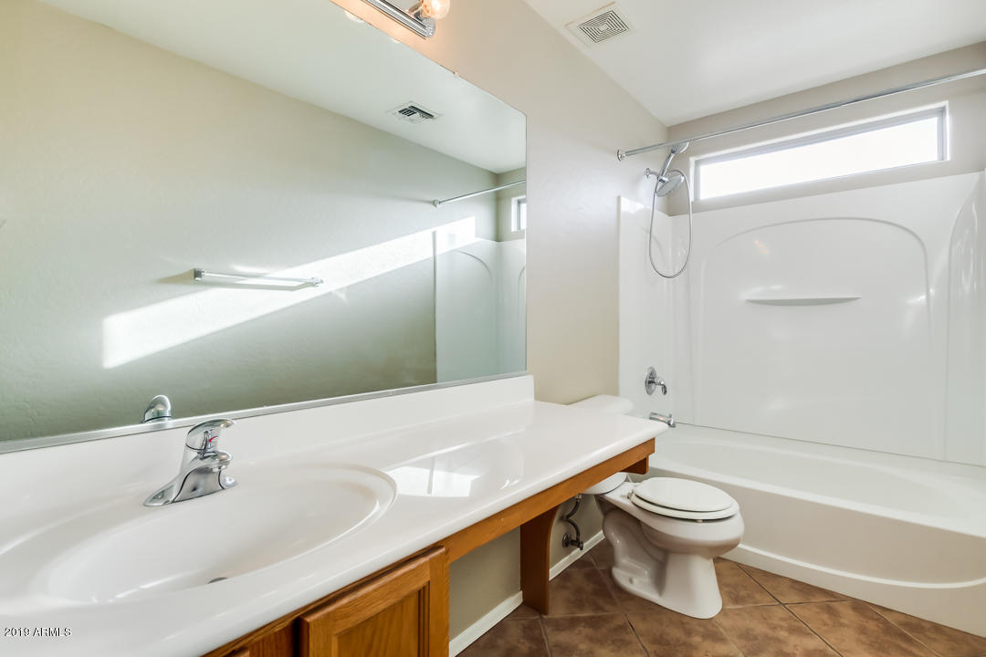 15917 West Calavar Road Surprise, AZ 85379 - Photo 27 of 40 a bathroom with a sink a toilet and a large mirror