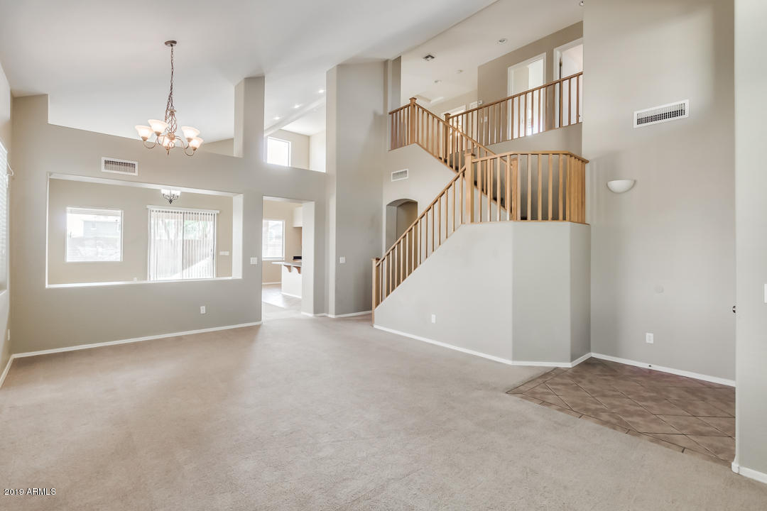 15917 West Calavar Road Surprise, AZ 85379 - Photo 3 of 40 a view of an empty room with chandelier fan and windows