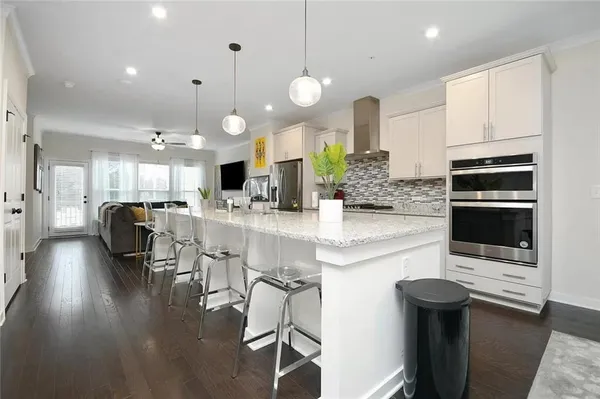 a kitchen with stainless steel appliances kitchen island granite countertop a stove a sink and a refrigerator
