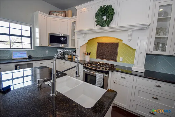 a kitchen with a stove a sink and a microwave