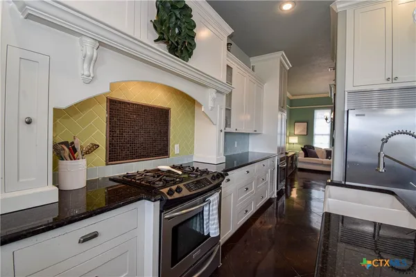 a kitchen with stainless steel appliances granite countertop a stove a sink and a refrigerator