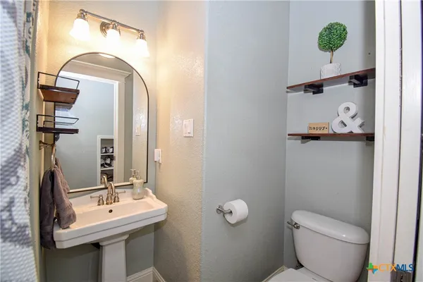 a bathroom with a toilet sink and mirror