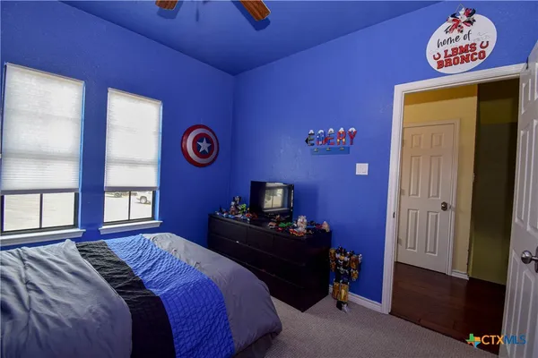 a bedroom with furniture and a flat screen tv