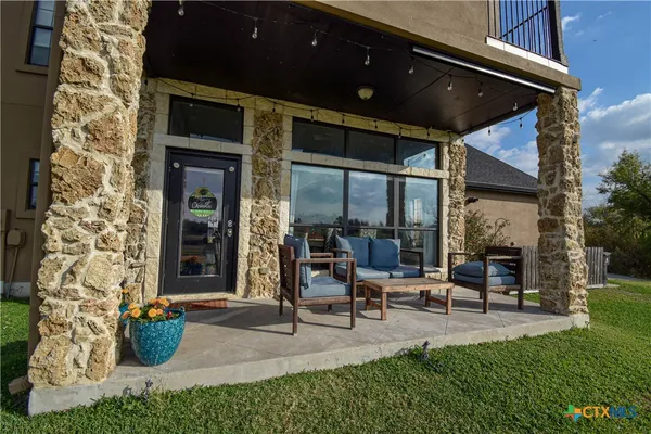 a building outdoor space with patio furniture and potted plants