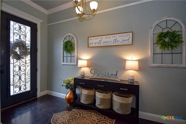a room with a table chairs and a chandelier