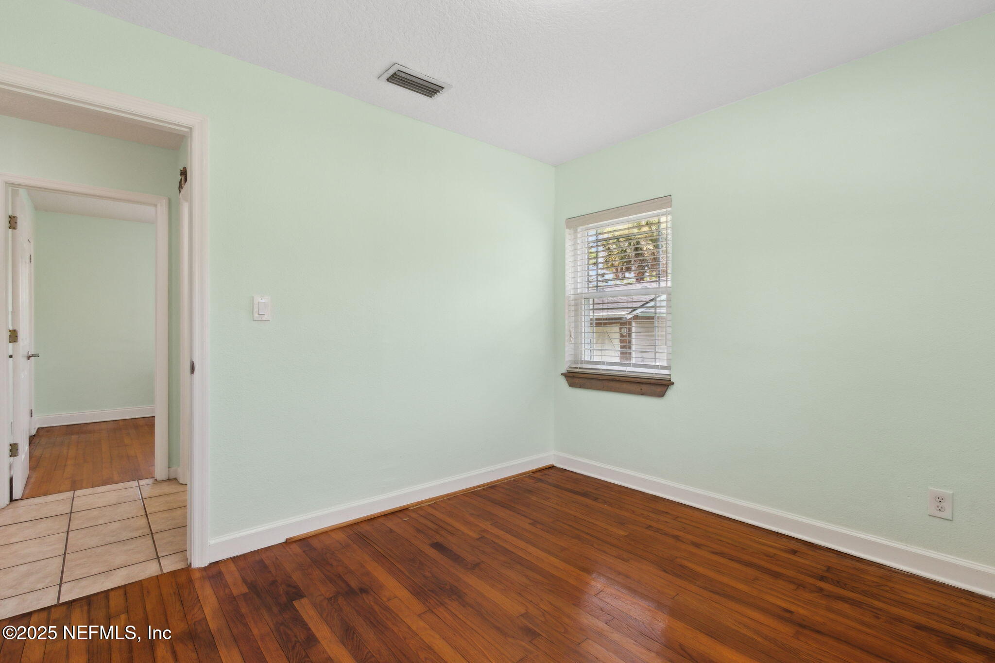 16062 Shark Road West Jacksonville, FL 32226 - Photo 18 of 43 a view of an empty room with wooden floor and a window