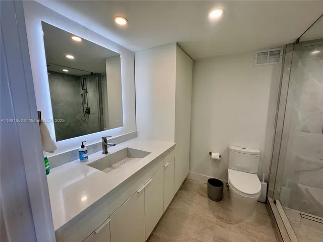 a bathroom with a double vanity sink toilet and mirror