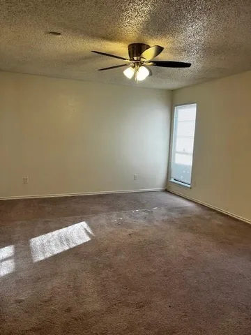 en empty room with windows and fan