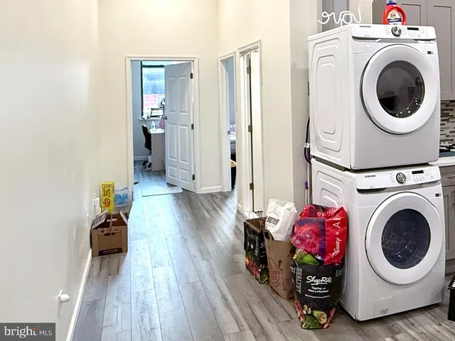 a living room with furniture a flat screen tv and a refrigerator