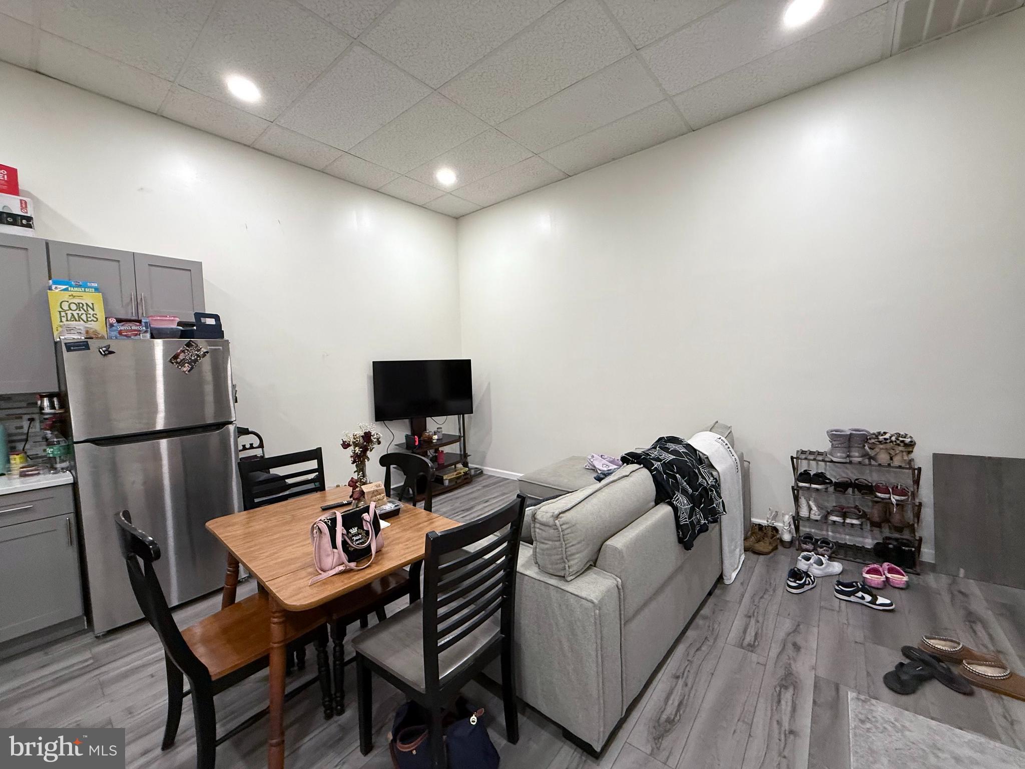 910 Arch Street, Unit 2F Philadelphia, PA 19107 - Photo 5 of 18 a living room with furniture a flat screen tv and a refrigerator