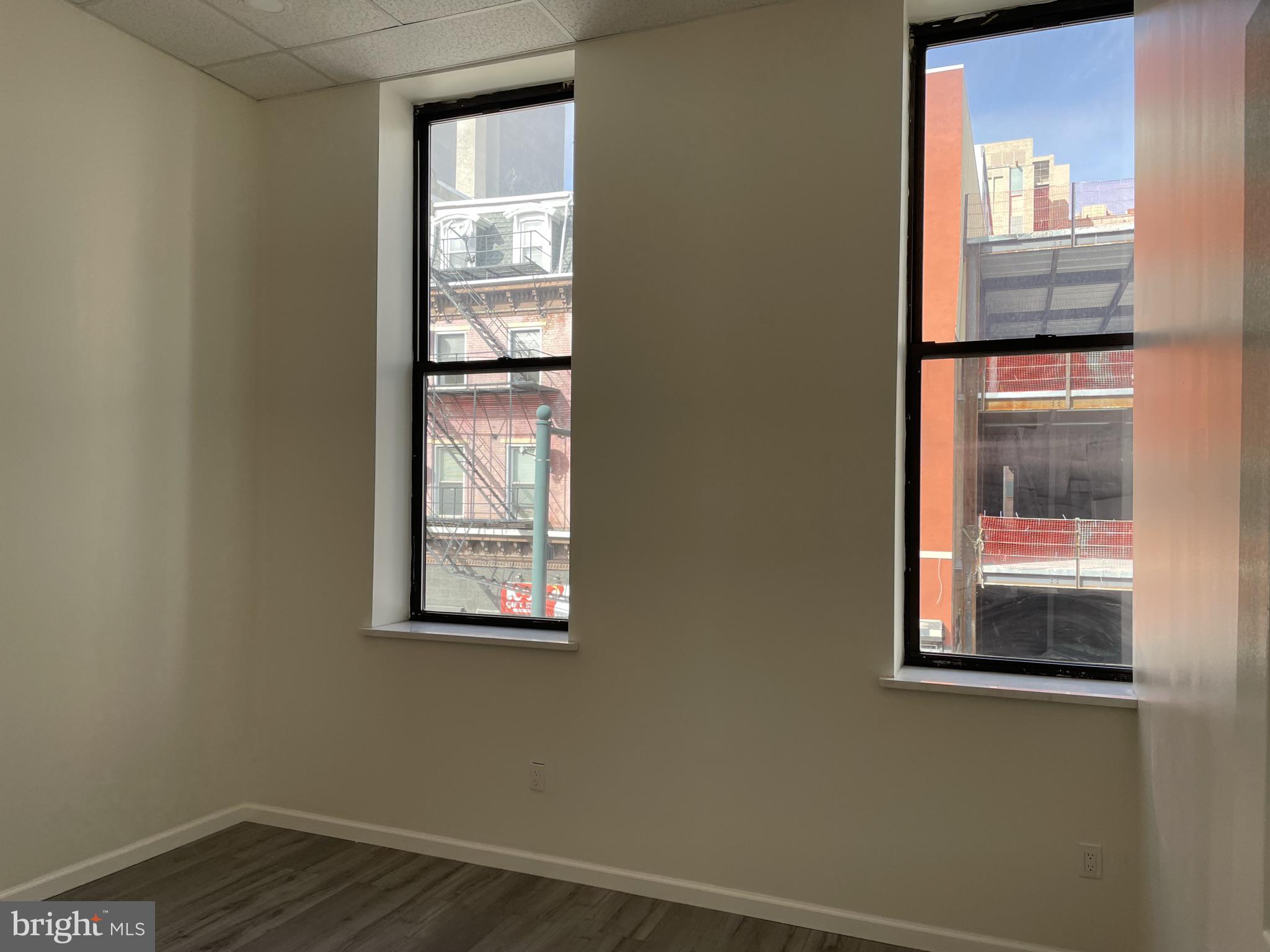910 Arch Street, Unit 2F Philadelphia, PA 19107 - Photo 7 of 18 a view of an empty room with wooden floor and a window