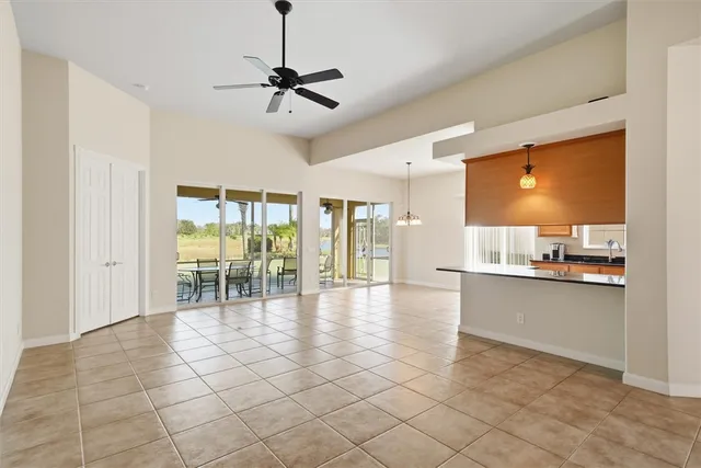 an empty room with a ceiling fan and window