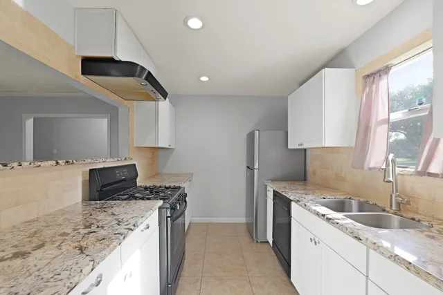 a kitchen with a sink stove and refrigerator