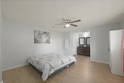 a spacious bedroom with a bed and a chandelier