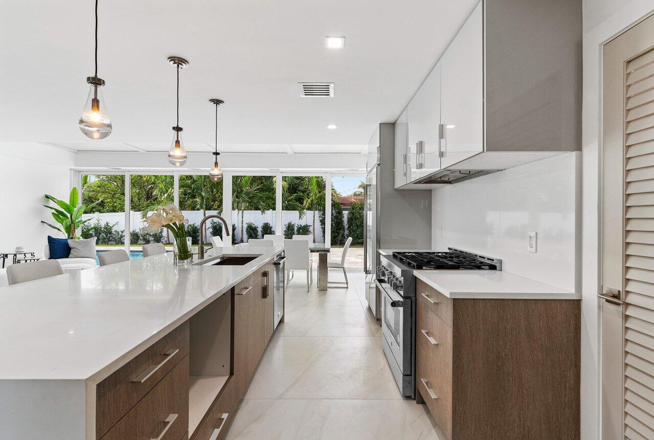 902 Southwest 27th Place Boynton Beach, FL 33435 - Photo 11 of 52 a kitchen with stainless steel appliances granite countertop a sink a stove and a wooden floors