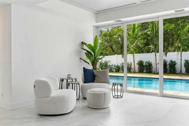 a dining room with furniture and a floor to ceiling window
