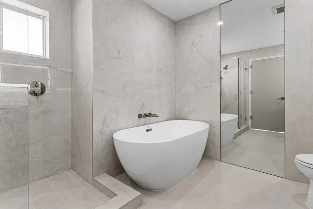 a bed sitting in a spacious bedroom next to a window