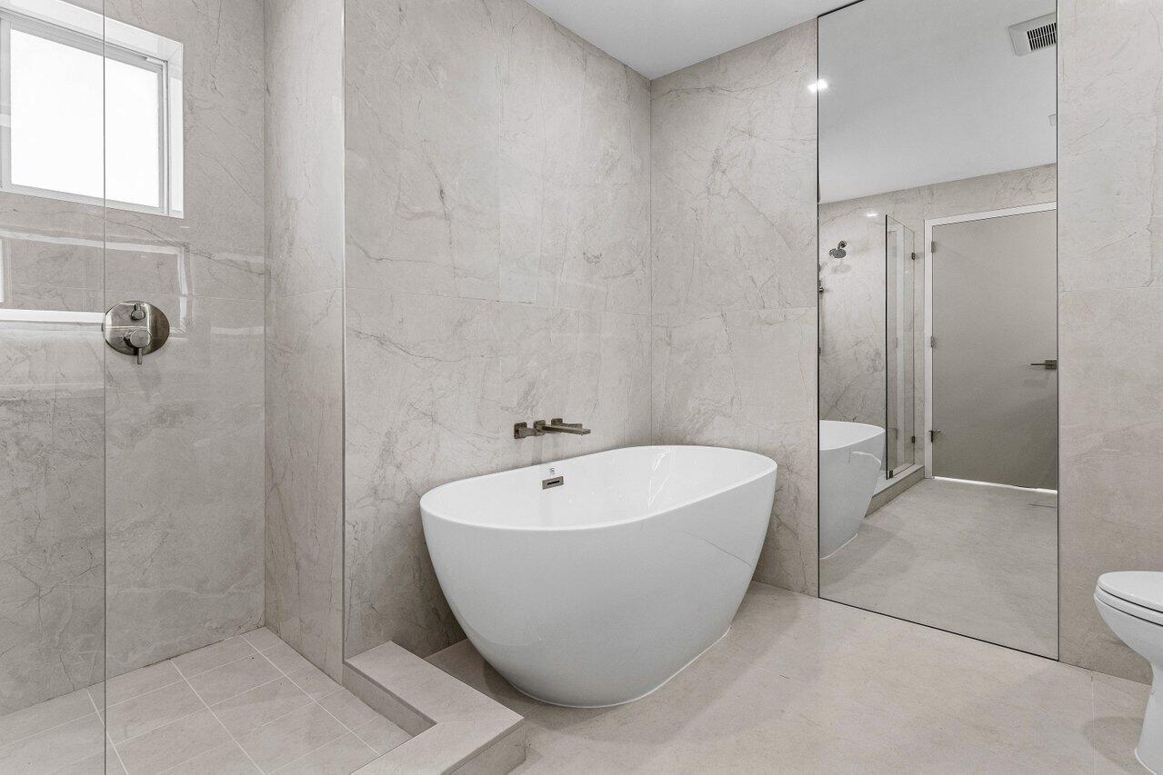 902 Southwest 27th Place Boynton Beach, FL 33435 - Photo 19 of 52 a white bath tub sitting in a bathroom and shower