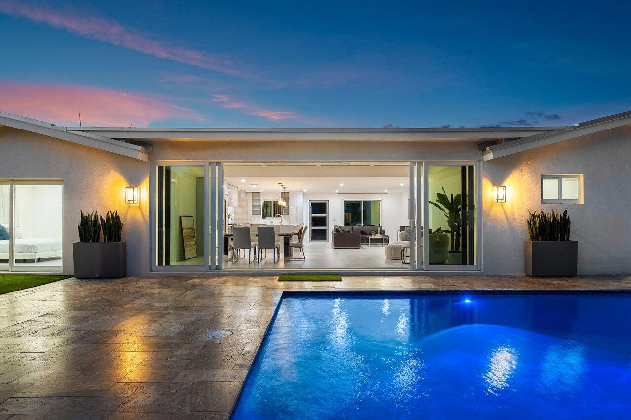 902 Southwest 27th Place Boynton Beach, FL 33435 - Photo 2 of 52 a swimming pool with outdoor seating