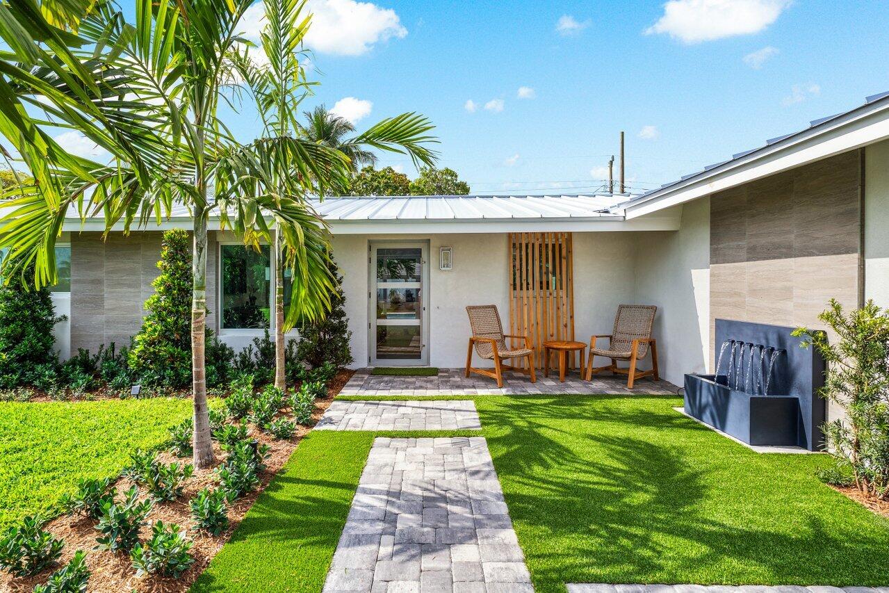 902 Southwest 27th Place Boynton Beach, FL 33435 - Photo 4 of 52 a front view of a house with a yard and porch