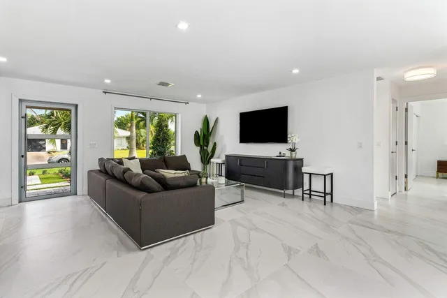 a kitchen with stainless steel appliances kitchen island granite countertop a table chairs and a refrigerator