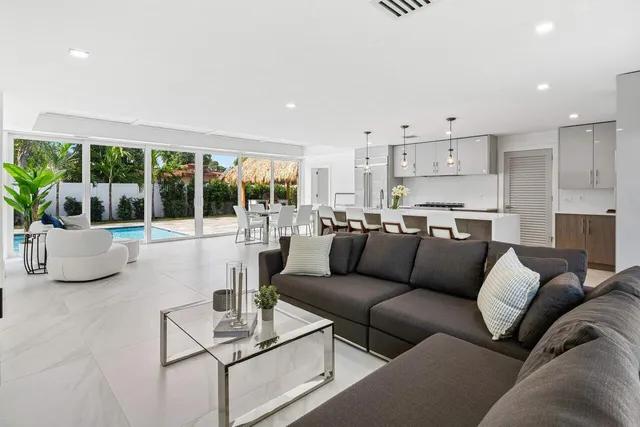 a kitchen with stainless steel appliances kitchen island granite countertop a table chairs and a refrigerator