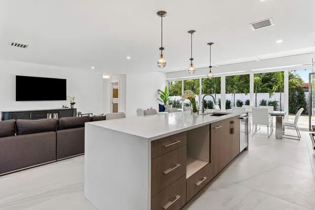 a kitchen with stainless steel appliances granite countertop a sink a stove and a wooden floors