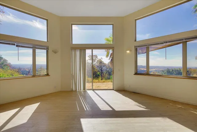 a view of a room with wooden floor and a window