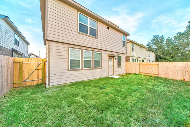 a view of a backyard with wooden fence