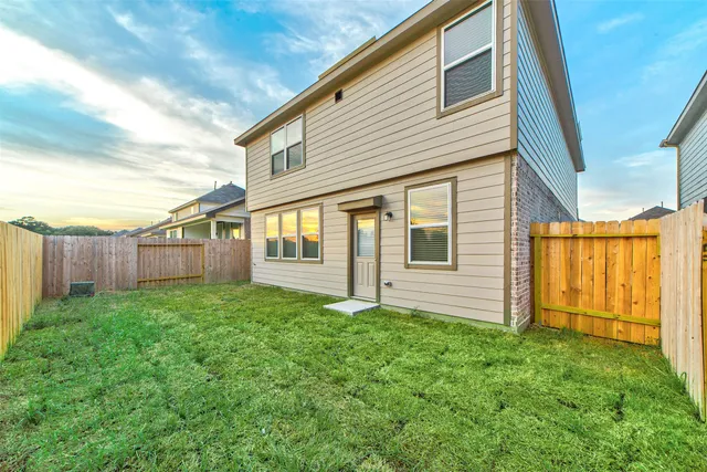 a view of backyard of house with green space