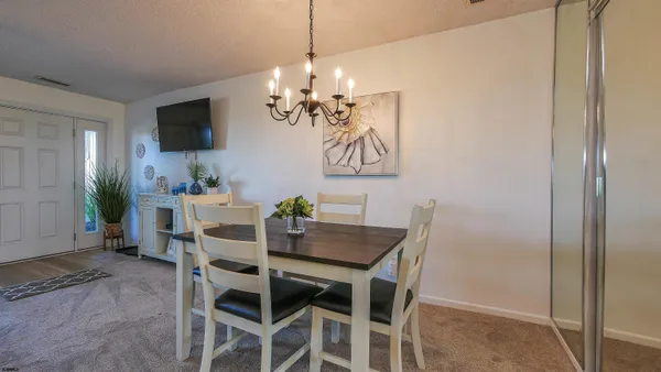 a view of a dining room with furniture and a chandelier fan