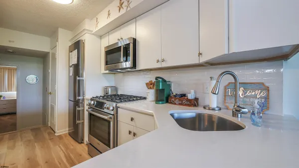 a kitchen with stainless steel appliances granite countertop a sink a stove and a refrigerator