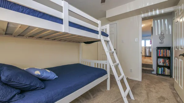 a bedroom with a bed and a lamp on dresser