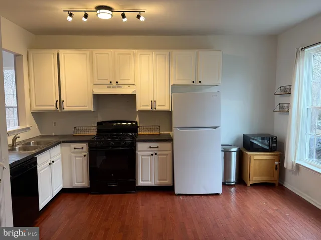 a kitchen with granite countertop a sink cabinets and stainless steel appliances