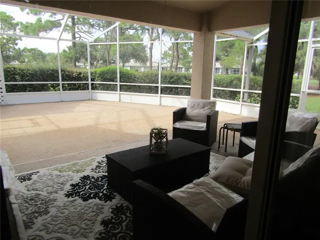 a view of a living room with a floor to ceiling window and wooden floor