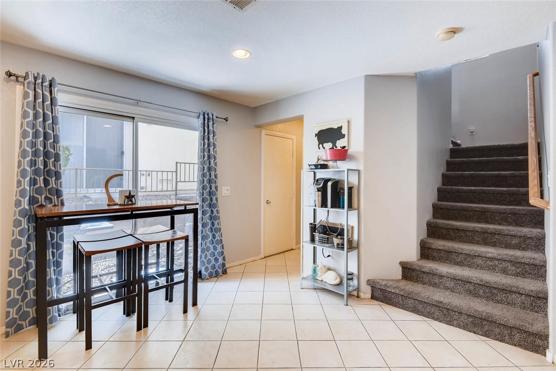 10451 Processor Court Las Vegas, NV 89129 - Photo 12 of 28 A cozy dining area features convenient sliding glass doors and durable tile flooring, perfect for casual meals.