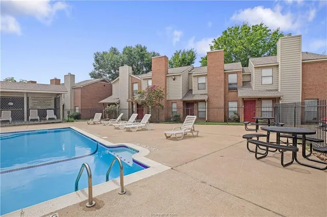 a view of a house with swimming pool and sitting area
