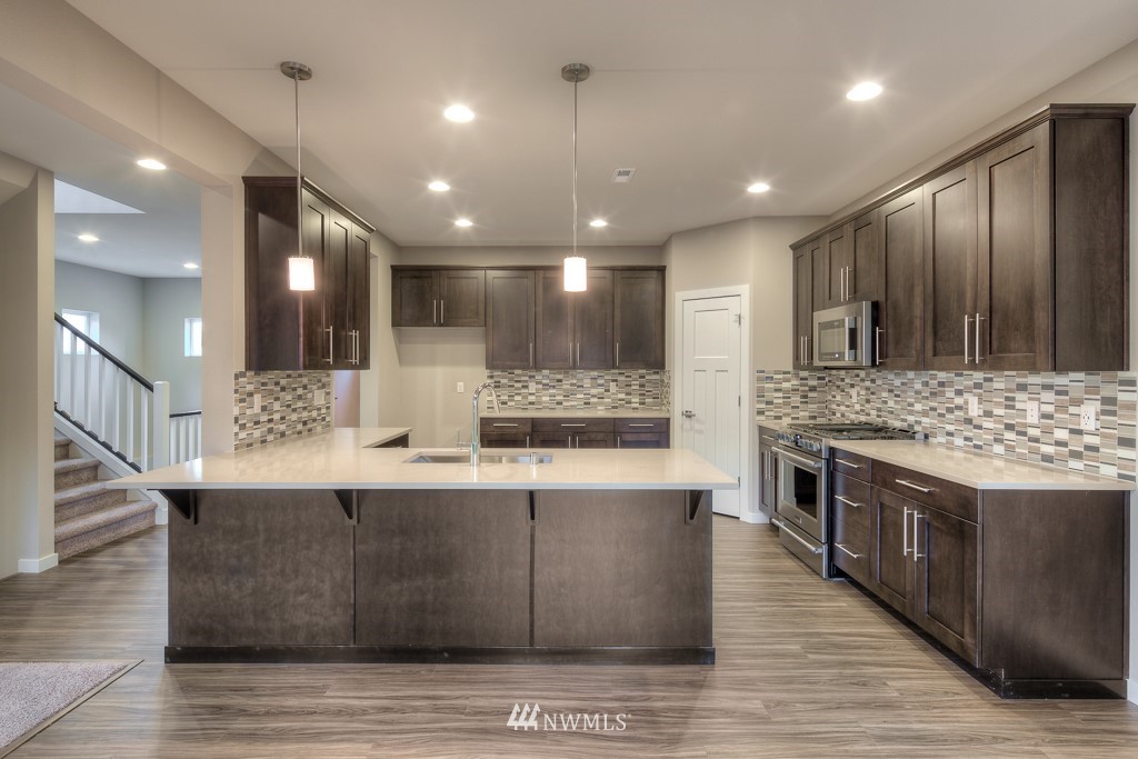 2125 228th Place Southwest, Unit EP12 Bothell, WA 98021 - Photo 4 of 16 a large kitchen with stainless steel appliances kitchen island a large island in the center