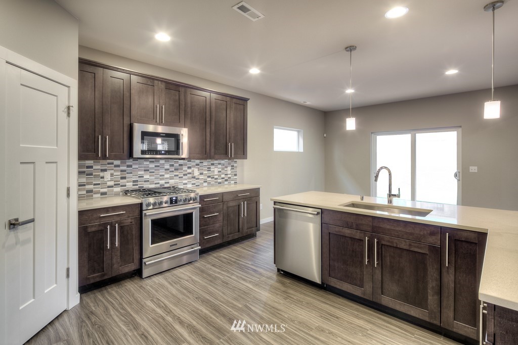2125 228th Place Southwest, Unit EP12 Bothell, WA 98021 - Photo 5 of 16 a kitchen with stainless steel appliances granite countertop a sink stove and cabinets