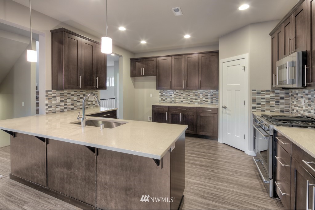 2125 228th Place Southwest, Unit EP12 Bothell, WA 98021 - Photo 6 of 16 a kitchen with kitchen island a sink stainless steel appliances and cabinets